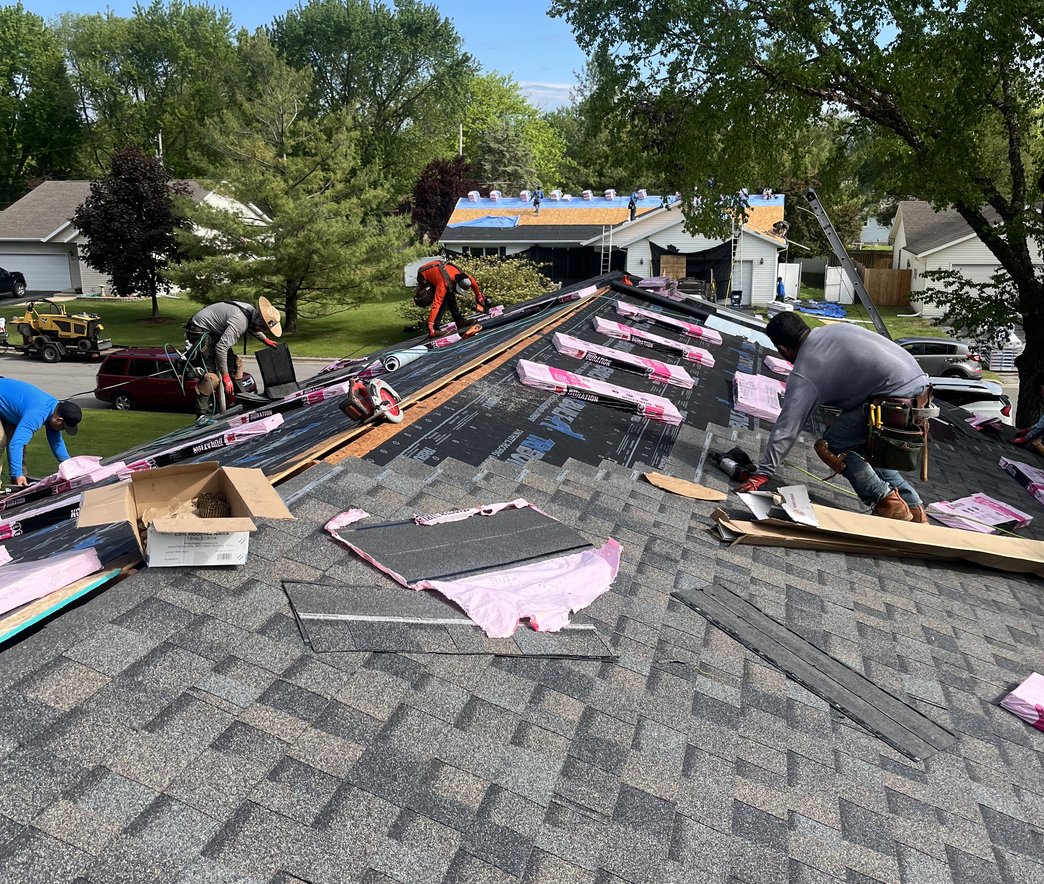 Roofer replacing shingles on a roof